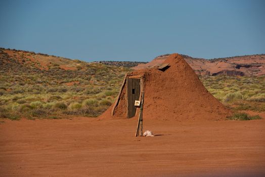 Navajo man-made clay hut with clear blue sky