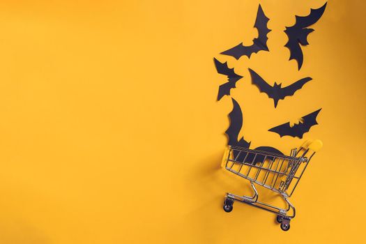 Festive halloween background with paper bats on a shopping trolley.Mock up flatly for party or sale. Top view.Copy Space