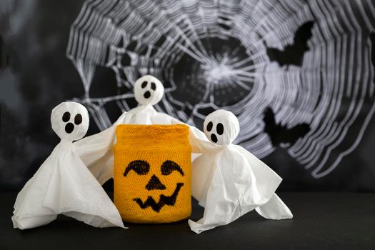 Three casts hugs pumpkin against background of cobwebs and bats. Concept of halloween .