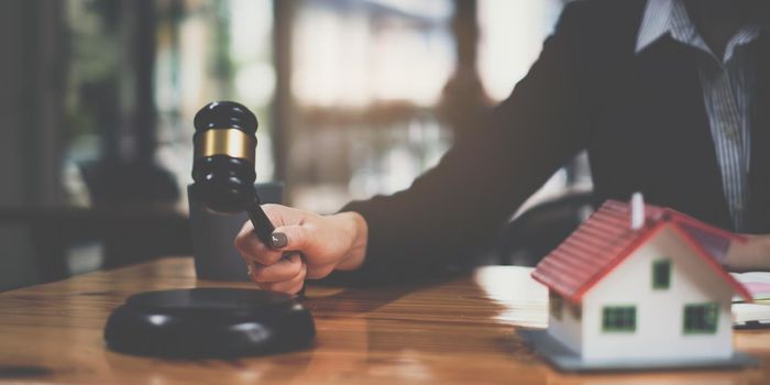 Business woman or legal advisor sitting wooden desk in office. Law, legal services, advice,Judge auction and real estate concept.