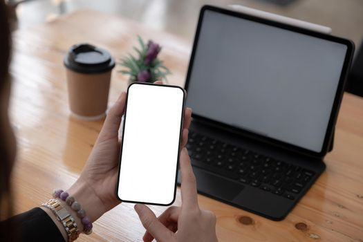 A Woman hand holding smartphone device with blank screen. Blank screen for your advertising