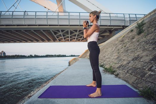 Woman exercising kettlebell pilates outdoor.