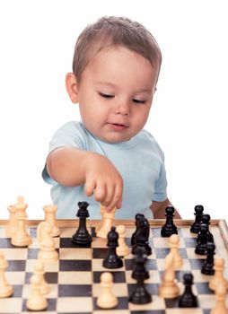 little boy staring at the chess pieces