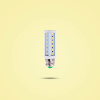 LED energy saving lamp 230v isolated on yellow pastel color background.