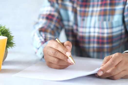 Close up of man hand writing on notepad