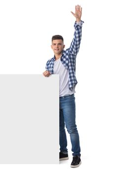 Full length portrait of a smiling young handsome man with blank banner waving hand