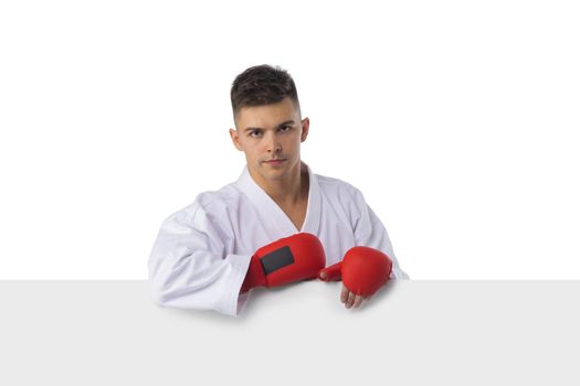 Man fighter training taekwondo with blank banner isolated on white background