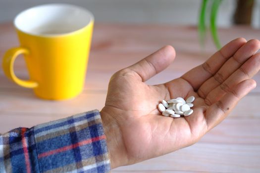 man's hand with pills spilled out of the container .