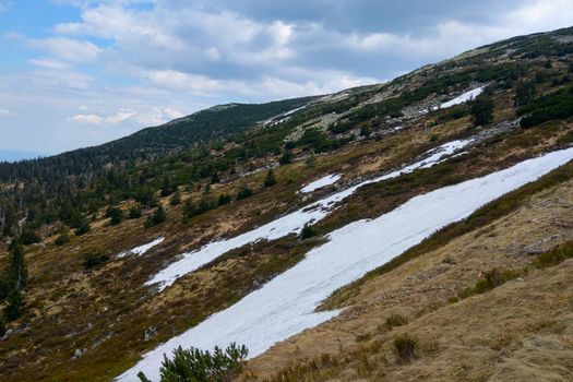 On the slope of the mountain lies snow in autumn