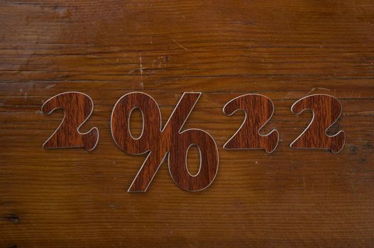 Happy New Year 2022. Number 2022 with sign percent on a wooden background. Big sale, black friday 