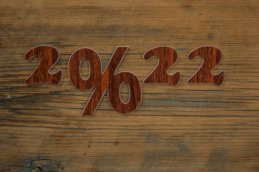 Happy New Year 2022. Number 2022 with sign percent on a wooden background. Big sale, black friday 