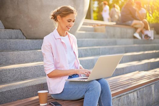 Businesswoman sitting stairs summer park using laptop Business person working remote. Outdoor Successful European caucasian woman freelancer make video call teacher study work online lessons