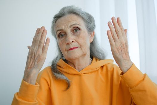 Closeup portrait of angry upset senior mature woman talking with someone and looking at the camera. Negative emotion, facial expression, scandal.