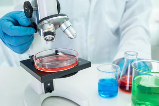 Asian scientist biochemist or microbiologist working research with a microscope in laboratory. For protect outbreak Coronavirus Covid19, bacteria and germs.