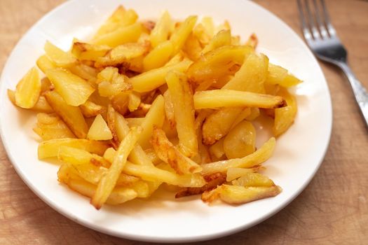 Fresh golden chips on a white plate. Delicious vegetable dish.