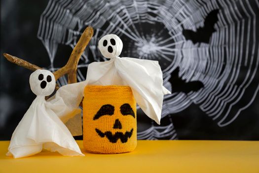 Two ghosts, candlestick with scary Halloween grimace on background of cobweb. Halloween Concept