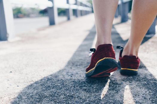 On a green background, a woman walks and runs while wearing running shoes. Exercise for health is a notion.