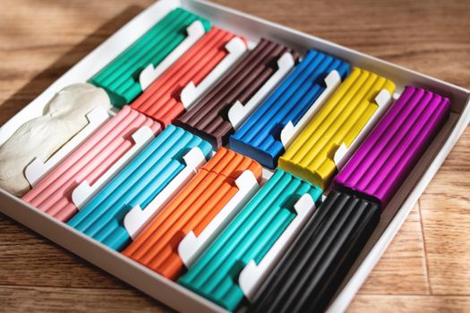 Multicolored plasticine on a wooden table close up