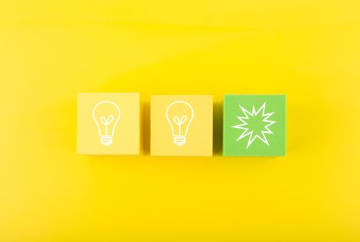 Concept of idea, creativity, start up or brainstorming. White drawn bulbs on yellow and green toy blocks against bright yellow background 