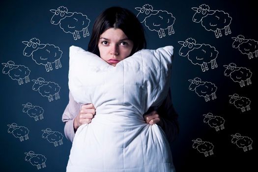 Funny girl with disgruntled offended face hugs a pillow. Young woman did not sleep well, she has trouble sleeping, woken up. Health problems with insomnia, need an orthopedic pillow, self-care, rest.