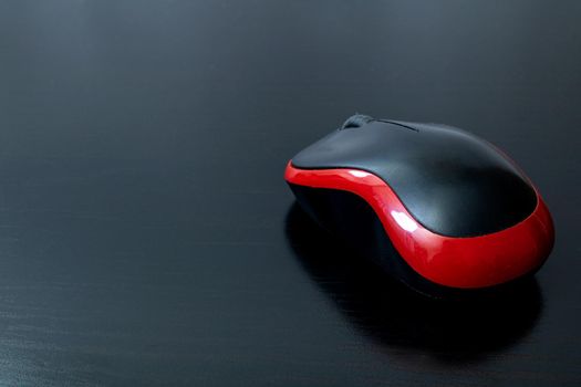 Black computer mouse on a wooden table, copy space