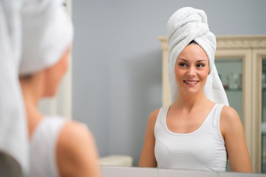 Portrait of young happy woman who is satisfied with her skin.