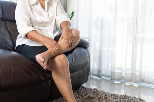 leg cramp, senior woman suffering from leg cramp pain at home, health problem concept