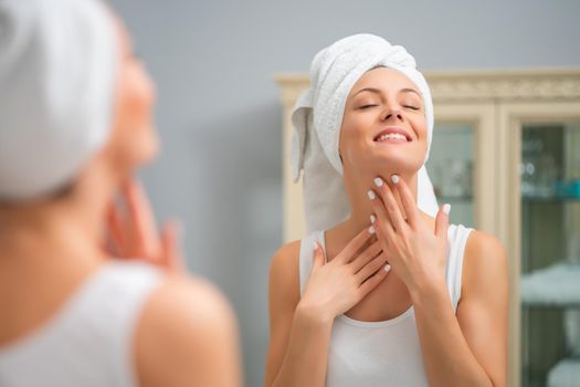 Portrait of young happy woman who is satisfied with her skin.