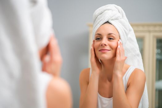 Portrait of young happy woman who is satisfied with her skin.