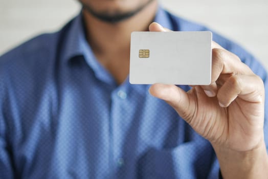 Man in casual dress showing credit card.