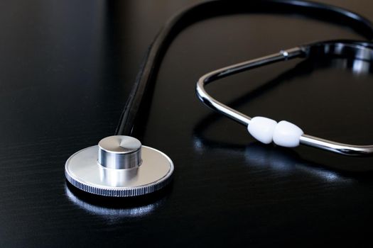 Medical stethoscope on a black table close up