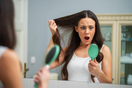 Young woman is in panic because of hair loss.