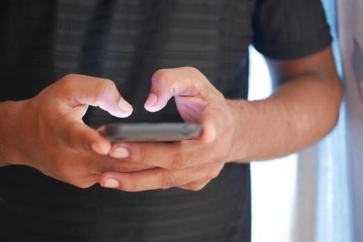 Close up of young man hand using smart phone