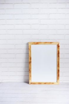 Black frame mockup on table against white wall