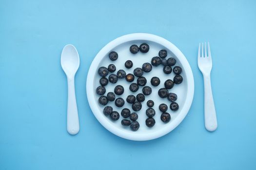 fresh blue berry on a plate on blue background ,