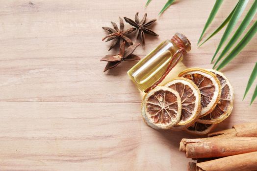 essential citrus oil, dried lemon and spice on table