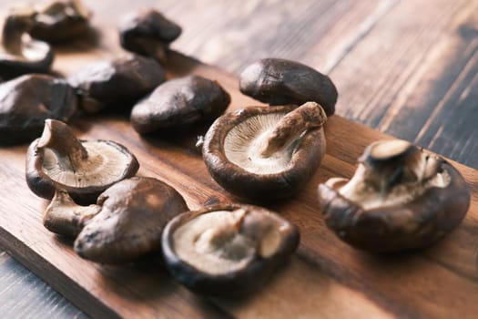 raw champignon mushroom on a chopping board on table .