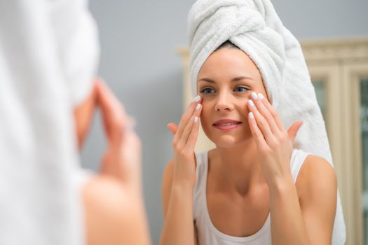 Portrait of young happy woman who is satisfied with her skin.