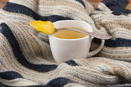 cozy autumn Breakfast with tea in white cup with honey and a warm knitted sweater  