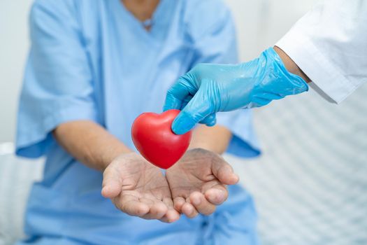 Doctor give red heart to Asian senior or elderly old lady woman patient, healthy strong medical concept