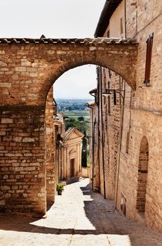 Picturesque narrow street in Spello ,Italy ,in the background church of Santa Maria del Prato