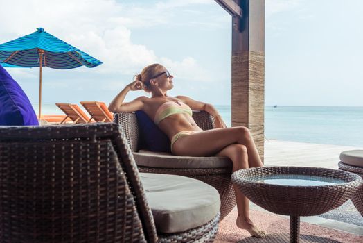 Young woman relaxing at the beach bar in Indonesia