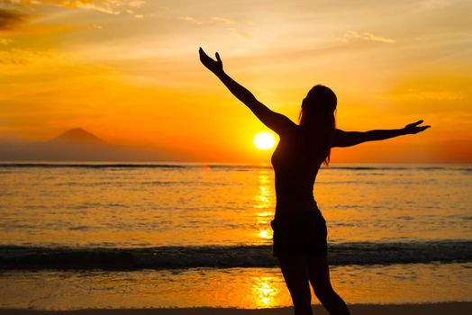 Young woman watching as sun sets over Pacific Ocean