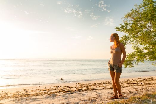 Young woman watching as sun sets over Pacific Ocean