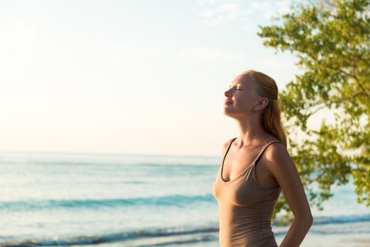 Young woman watching as sun sets over Pacific Ocean