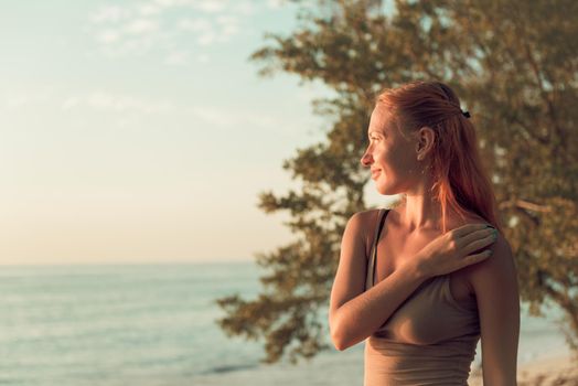 Young woman watching as sun sets over Pacific Ocean