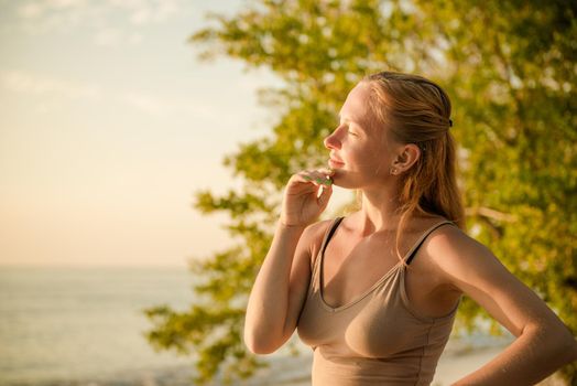 Young woman watching as sun sets over Pacific Ocean