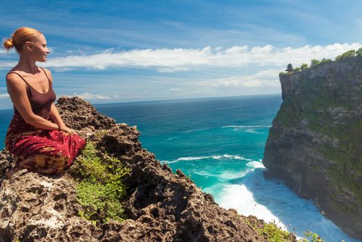 Happy young tourist posing near Uluwatu temple, Bali, Indonesia