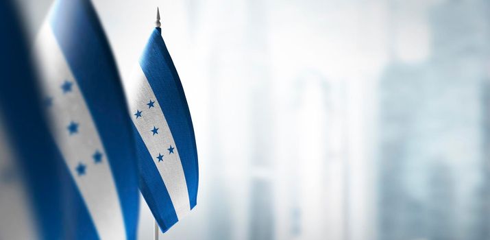 Small flags of Honduras on a blurry background of the city.