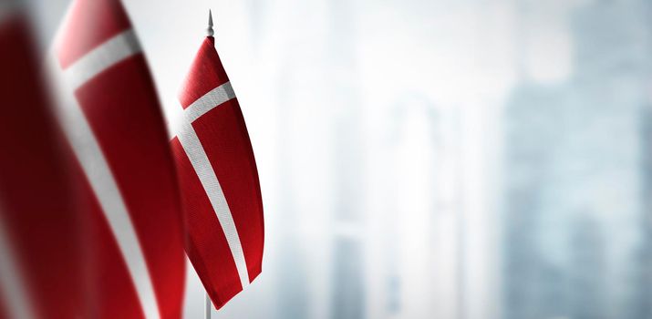 Small flags of Denmark on a blurry background of the city.